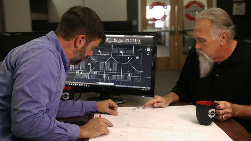 Bailiwick employees looking at schematic on a table
