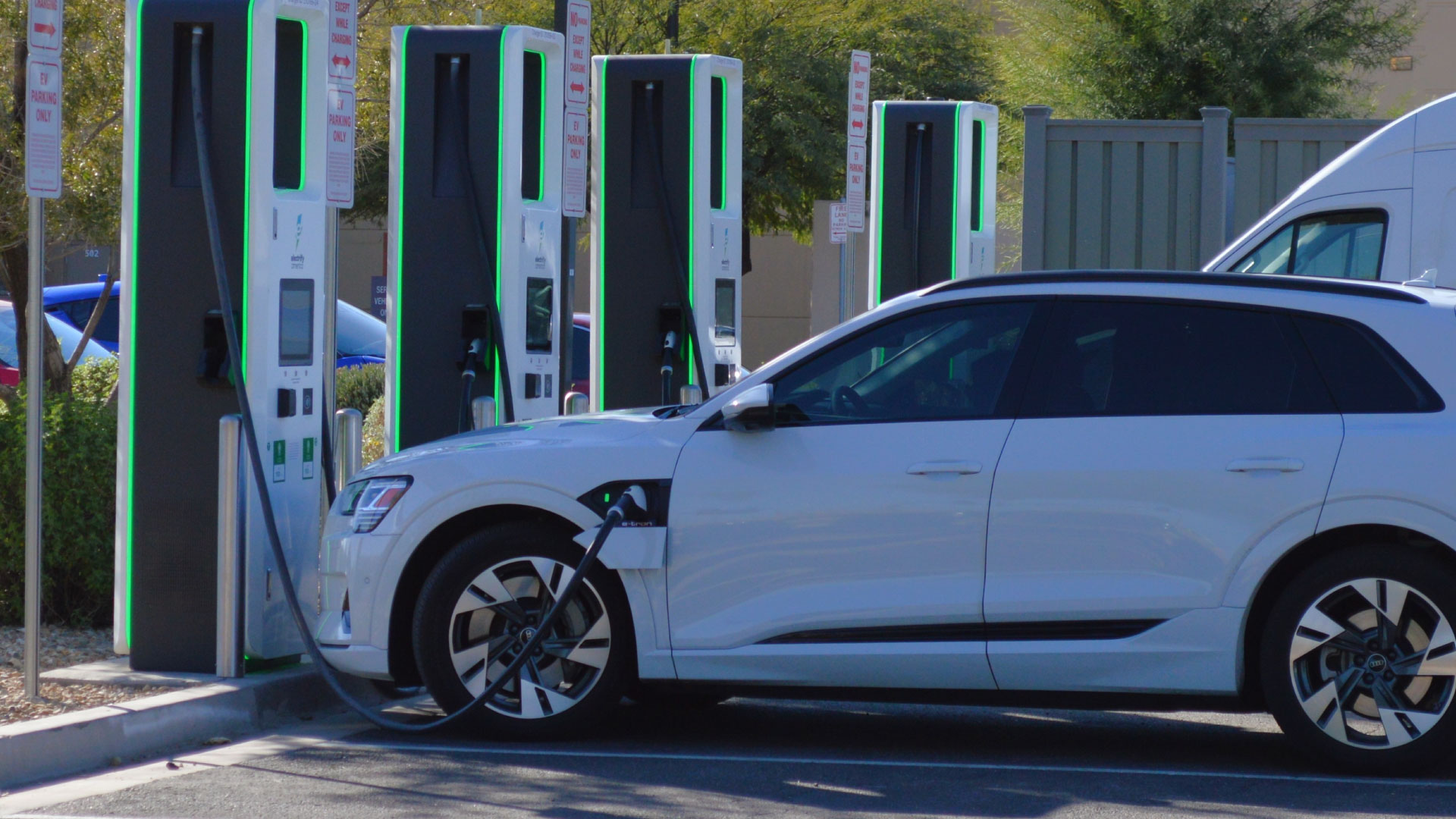 An EV car plugged into a charging station with batter statistics being shown